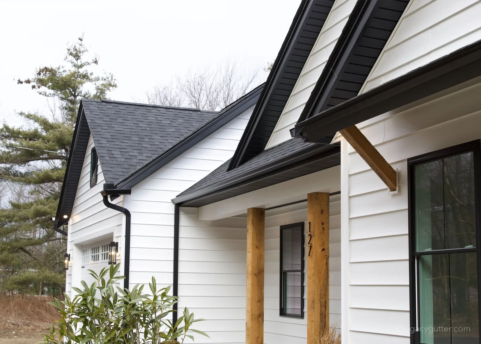 Black seamless gutters on a white farmhouse